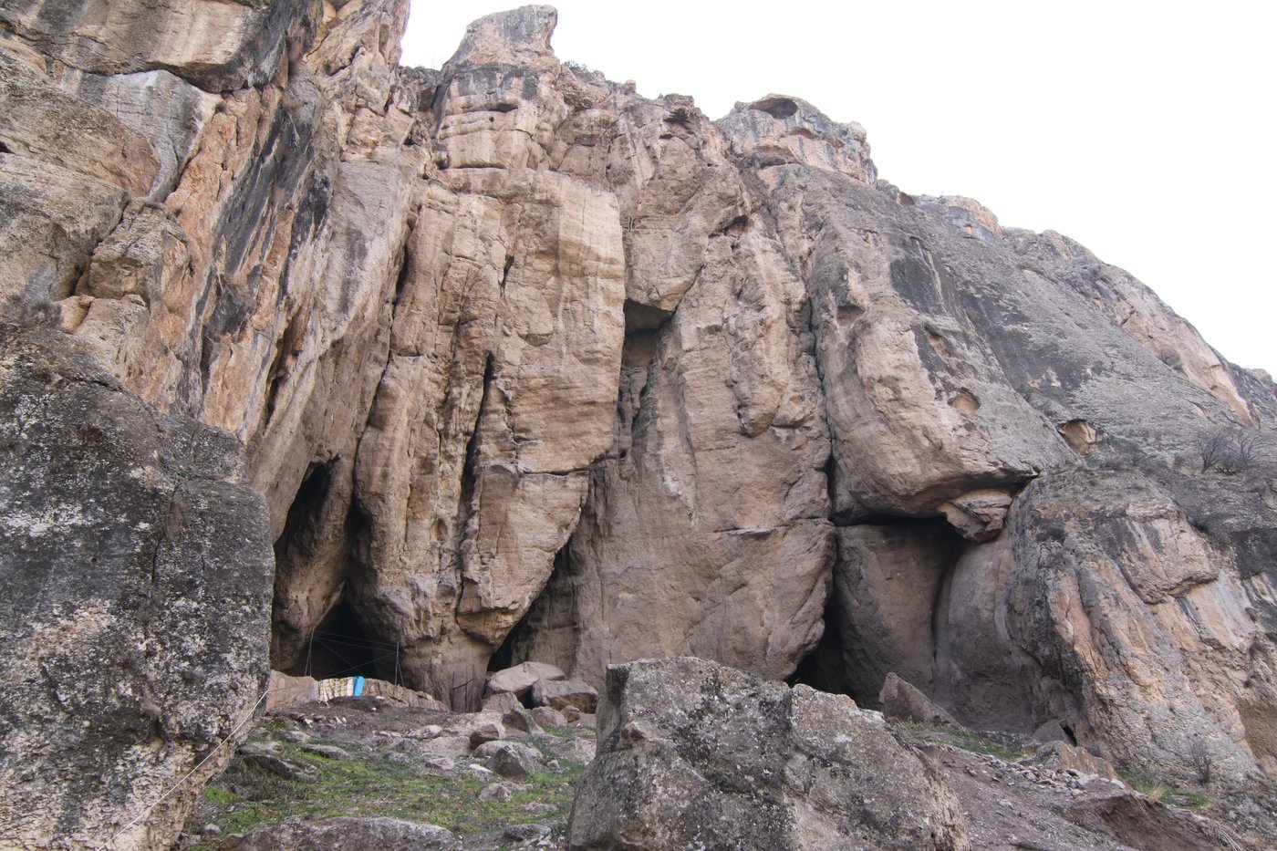 The wide rock entrance of the Areni-1 cave in the Armenian cliffs