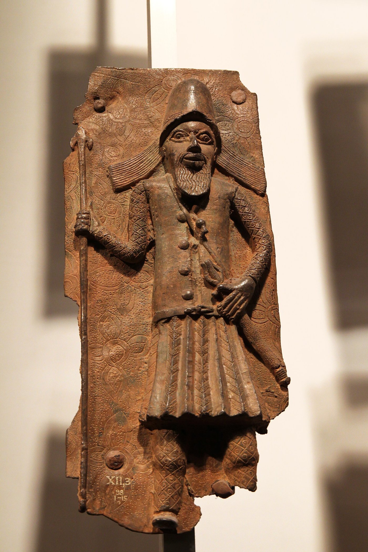 A cast brass Benin plaque showing court figures in high relief