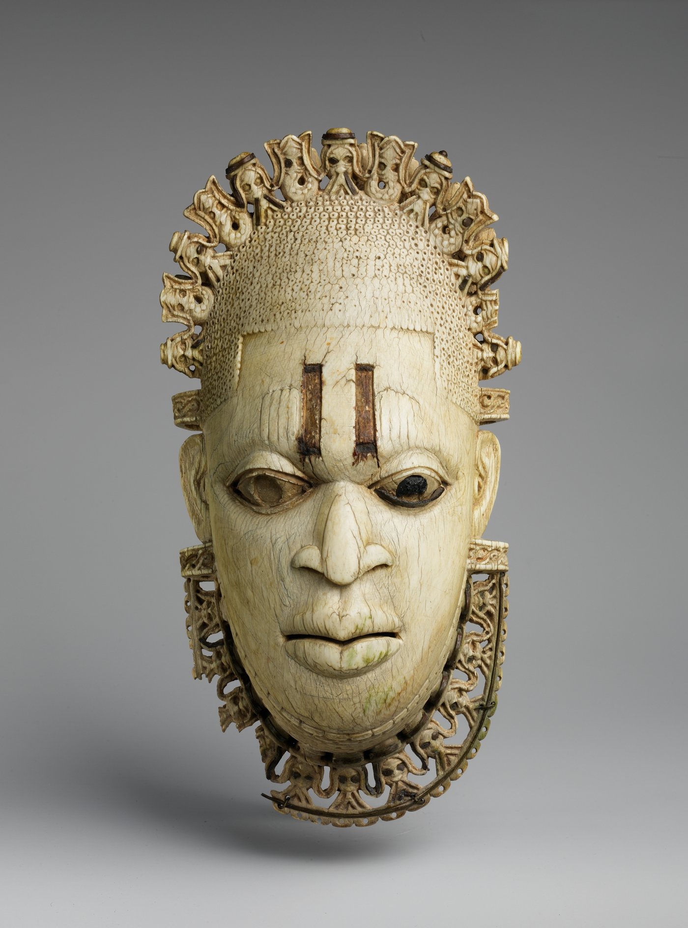 Ivory pendant mask of the Iyoba, the Queen Mother of Benin, carved with fine detail