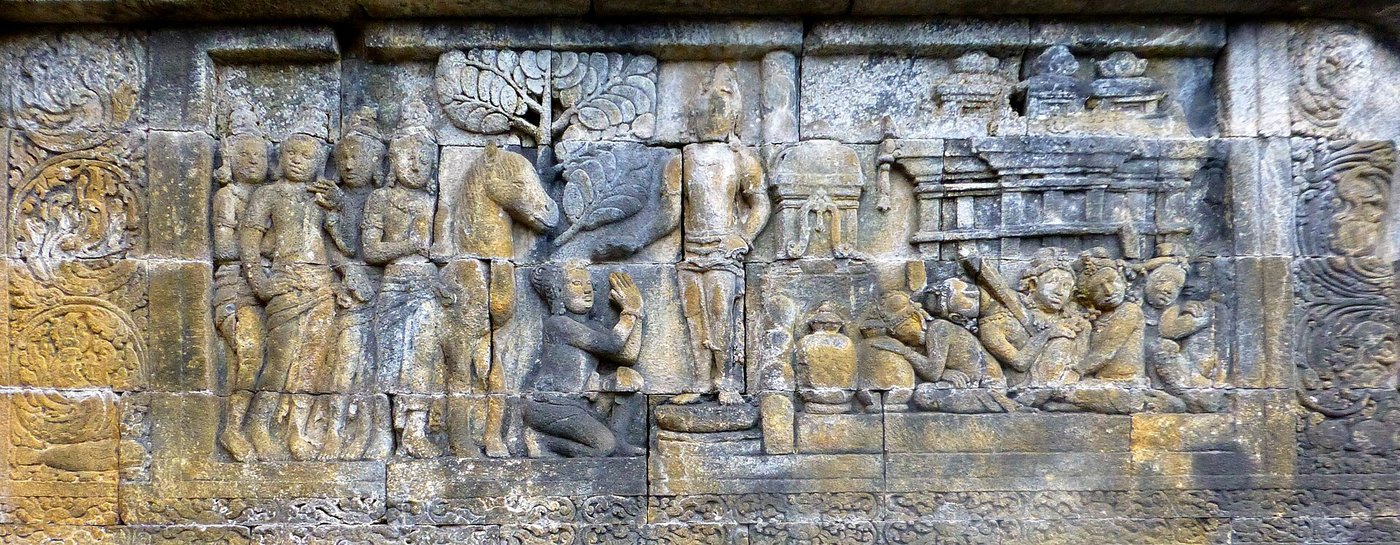 A carved stone relief panel from Borobudur showing Prince Siddhartha leaving the palace on horseback, attended by figures