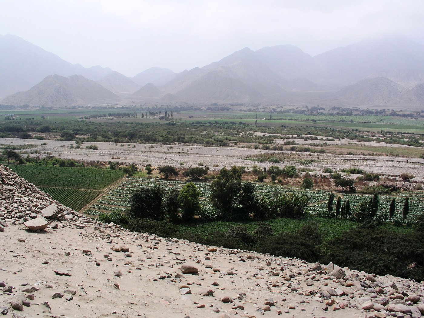 Wide view of the pyramid mounds of Caral rising from the dry Supe valley in Peru