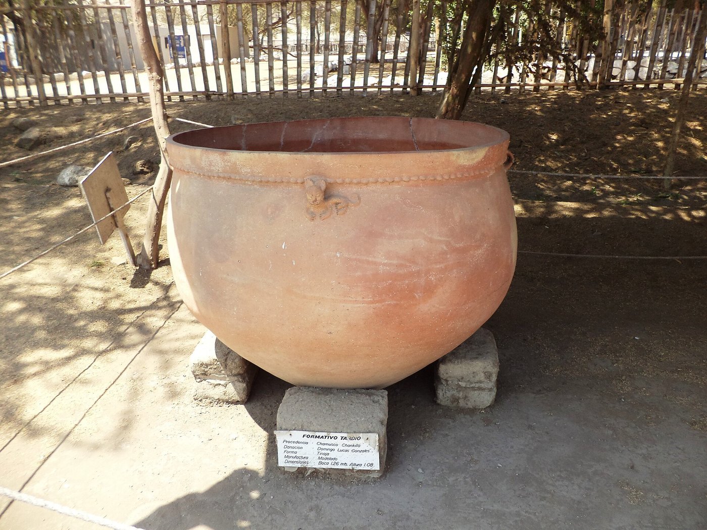 A dark Chimu stirrup-spout ceramic vessel modelled in a rounded form
