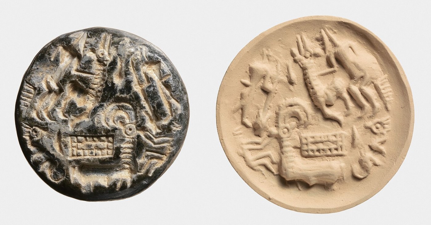 A round Dilmun stamp seal carved with figures, from the early second millennium BC