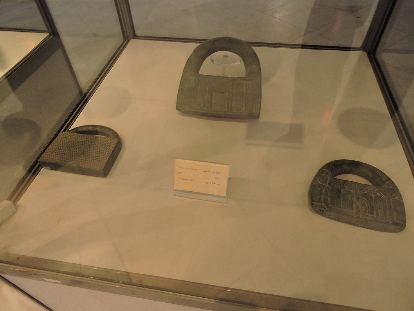Rows of carved dark chlorite vessels from the Jiroft culture on display in the Jiroft museum