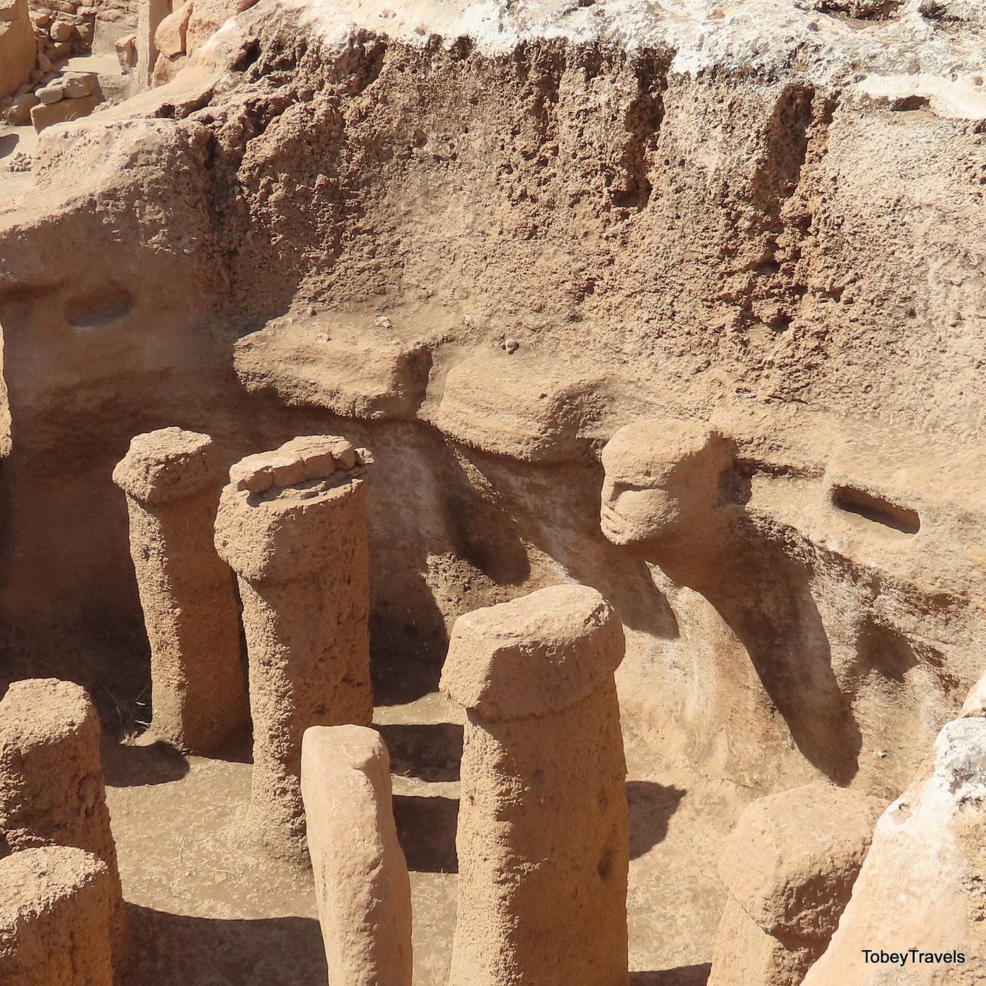 Structure AB at Karahan Tepe: a pit chamber of upright pillars with a carved human head emerging from the wall