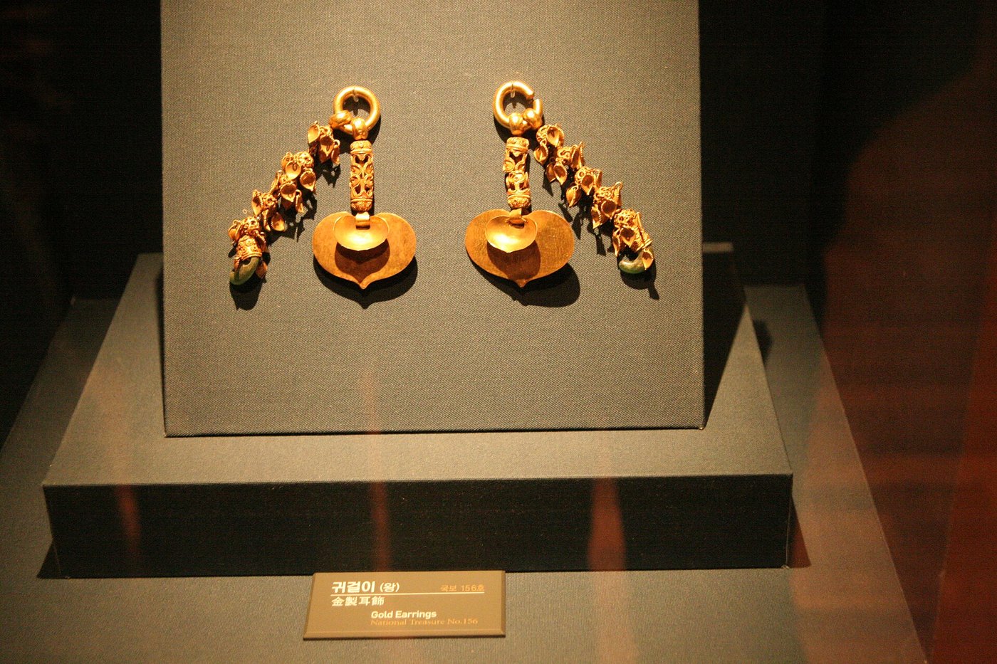 A pair of elaborate gold earrings from the Tomb of King Muryeong, formed from linked chains of gold ending in leaf-shaped pendants