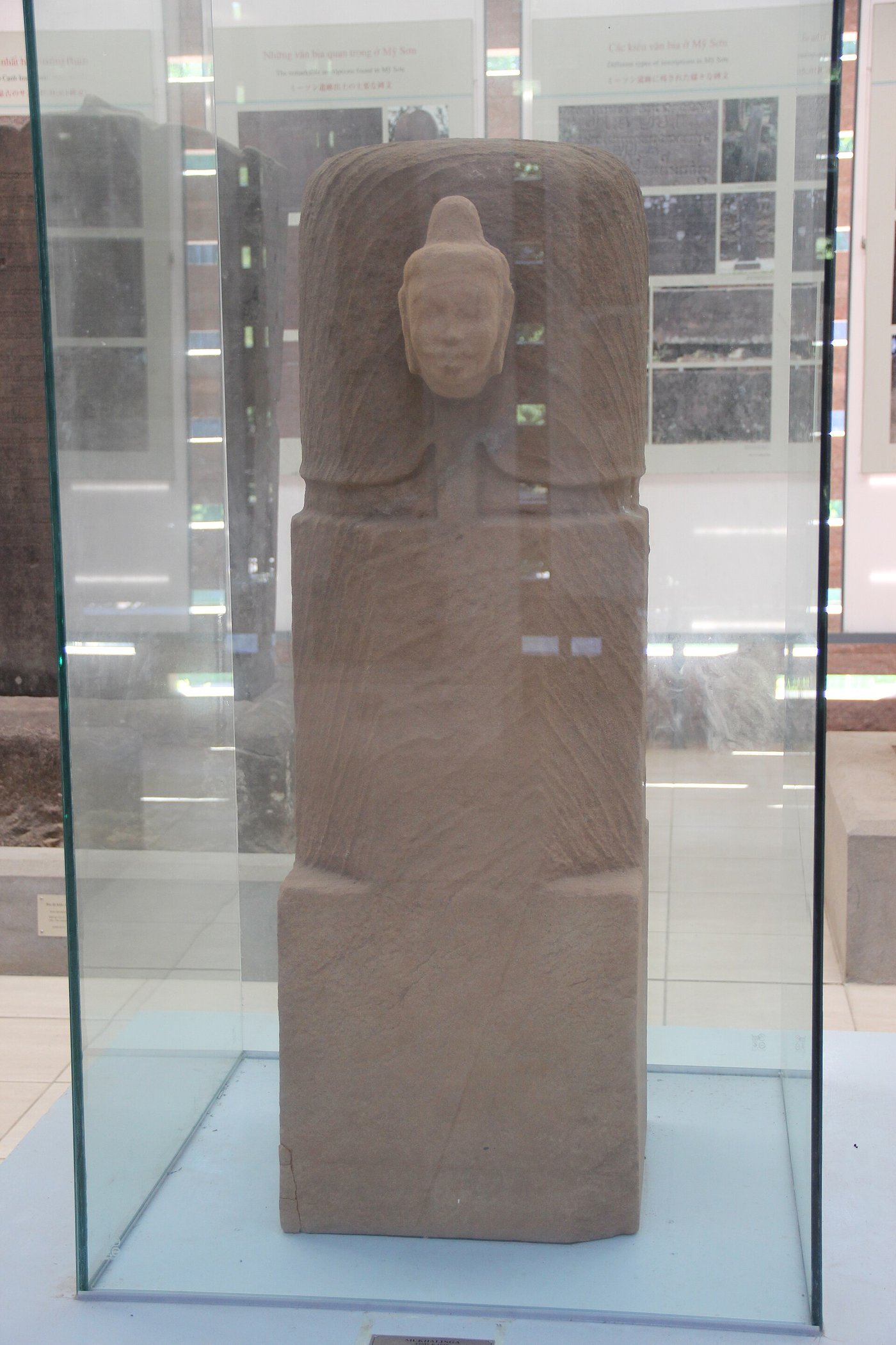 A one-faced stone linga, ekamukhalinga, from My Son showing the face of Shiva emerging from the pillar