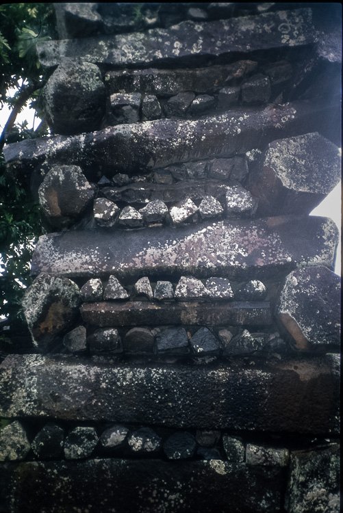 Close view of a Nan Madol wall showing long basalt columns stacked crosswise in alternating layers