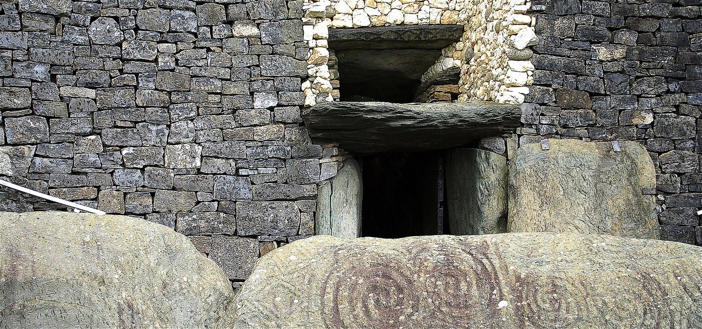 The entrance to Newgrange, showing the carved threshold stones and, above the lintel, the slot of the roof-box built to admit the solstice sun