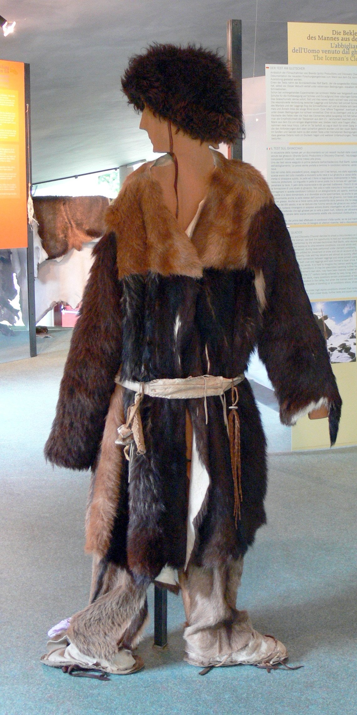 Reconstruction of Ötzi's clothing, including hide coat, leggings and grass cloak, on museum display