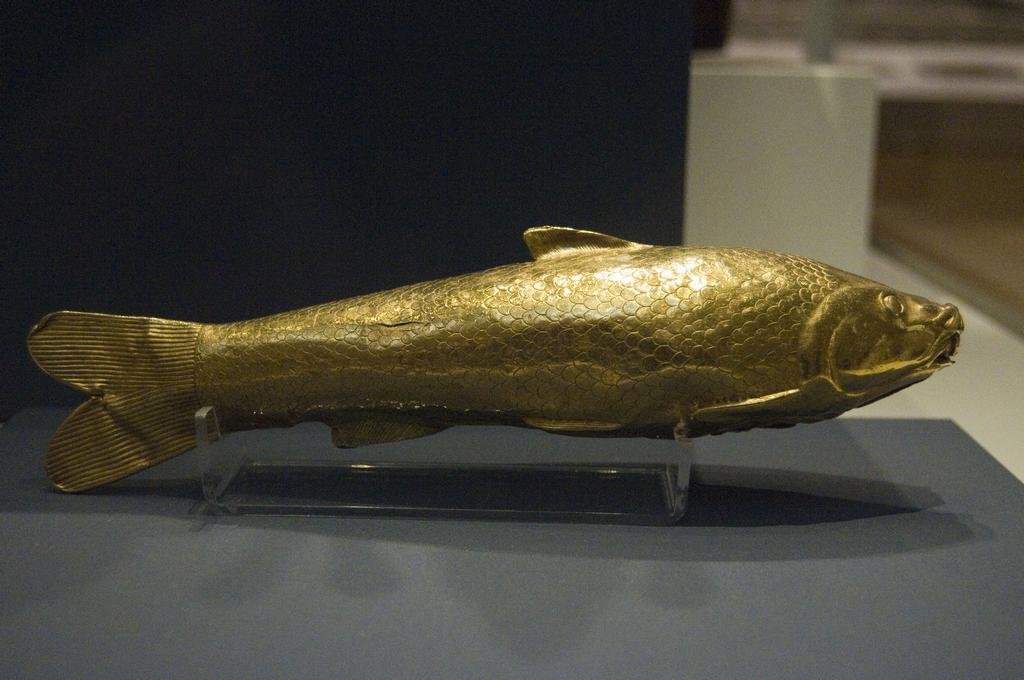 Hollow gold vessel shaped like a fish, its scales and fins worked in fine detail