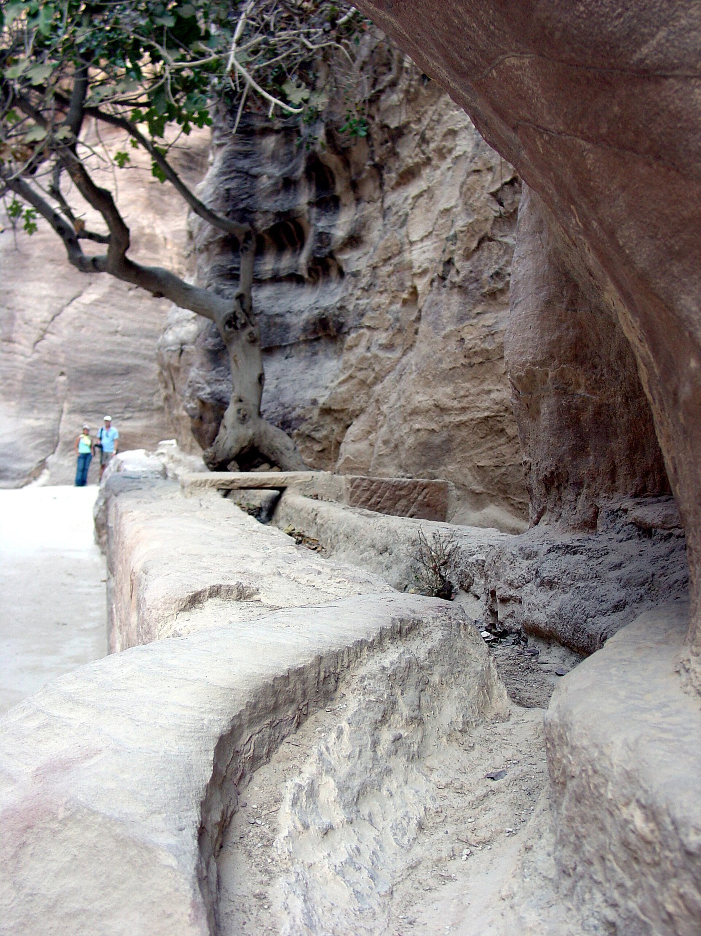 A carved water channel running along the sandstone wall of the Siq at Petra