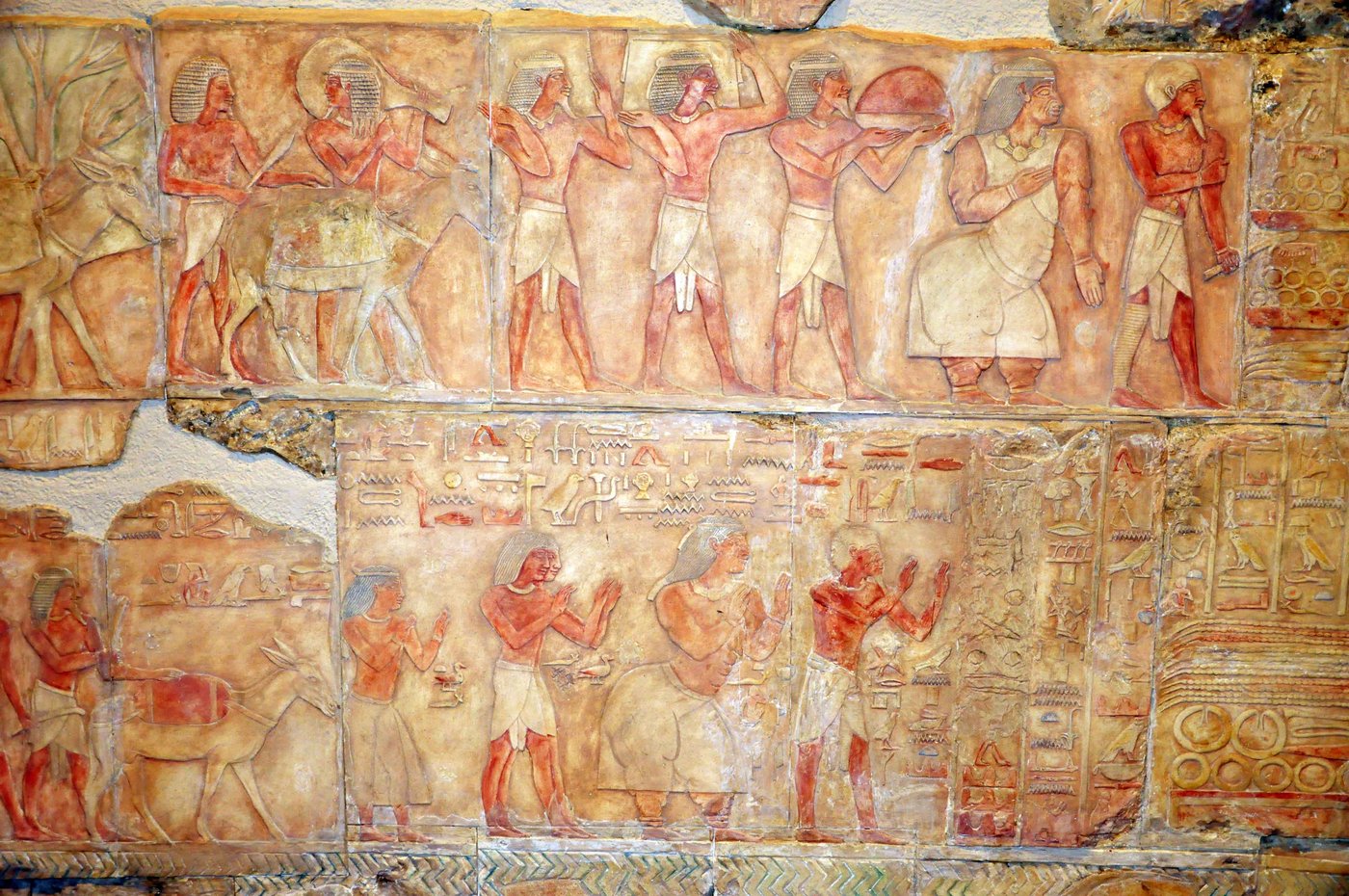 Painted Egyptian relief showing the pole houses of Punt among palm trees with Egyptian figures approaching