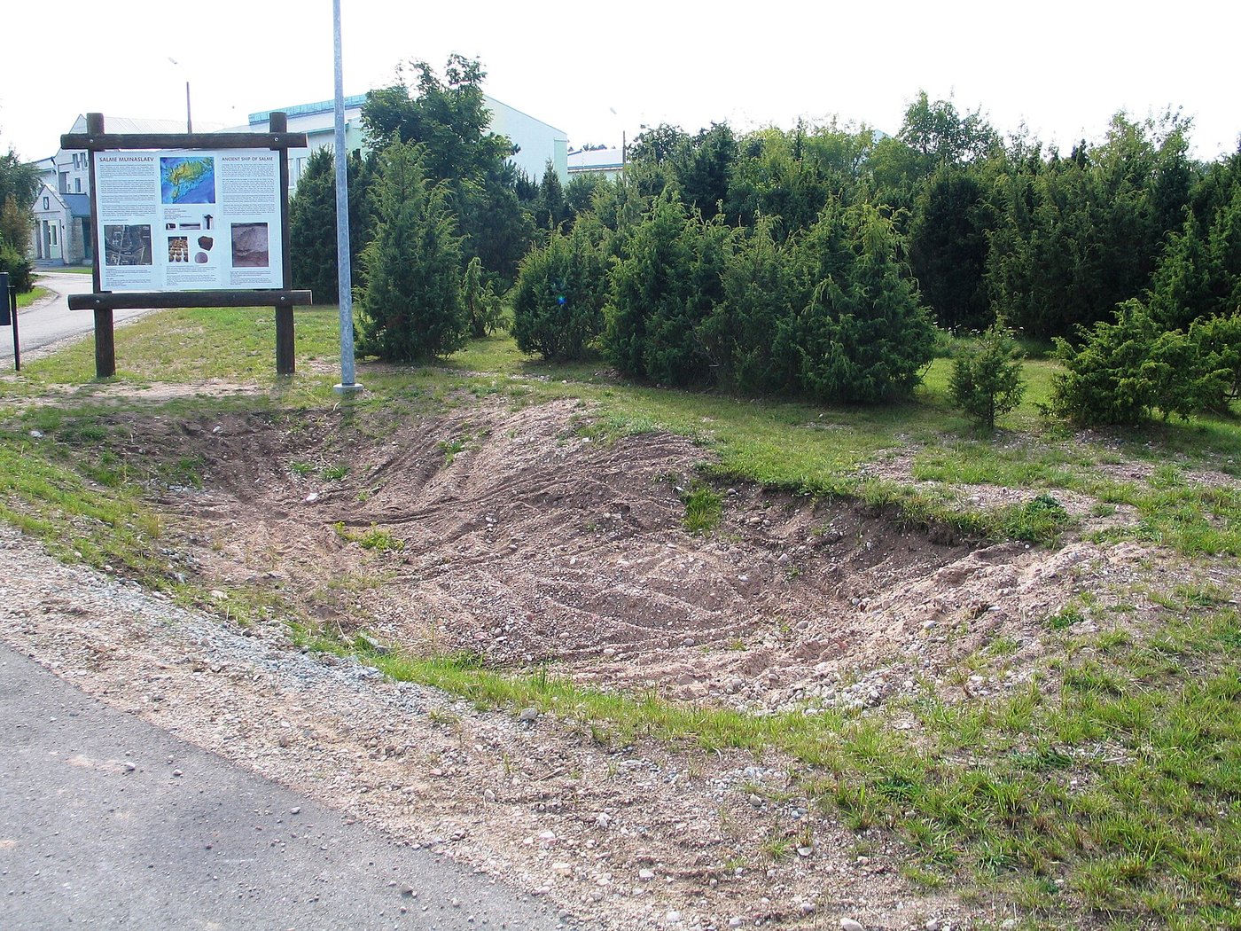 The roadside ground at Salme on Saaremaa where the two boat burials were found, marked today by an information board reading Ancient Ship of Salme