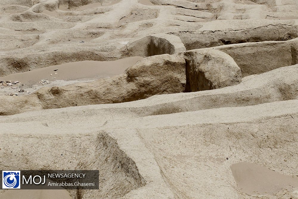 Excavated foundations and eroded brickwork at Shahr-e Sukhteh under strong desert light.