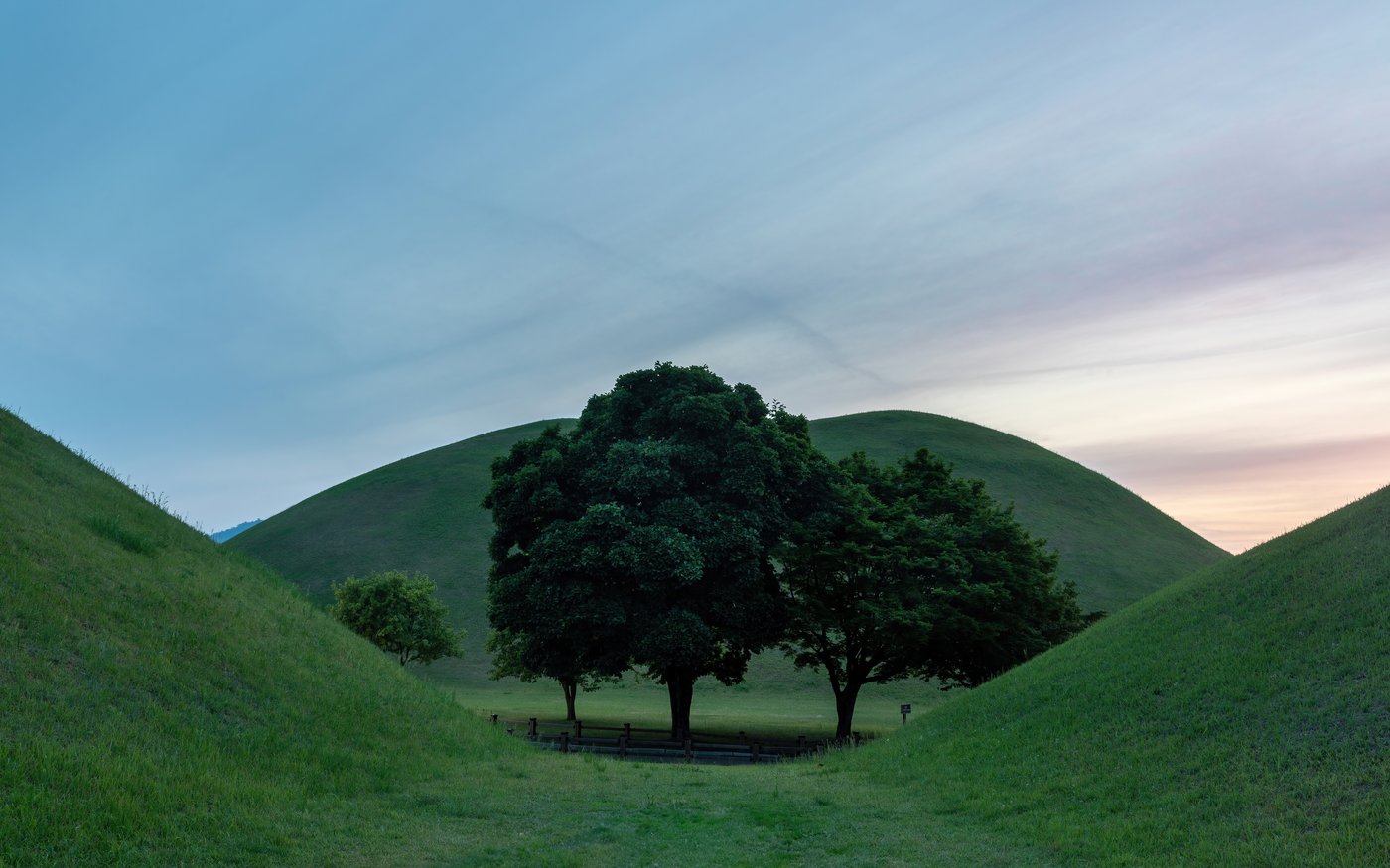 Grassy domed royal tomb mounds of Silla at Daereungwon in Gyeongju at sunset