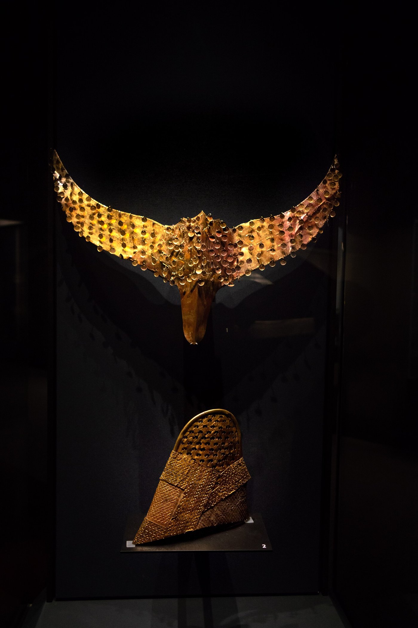 A tall Silla gold inner cap and a winged gold crown ornament displayed at the National Museum of Korea
