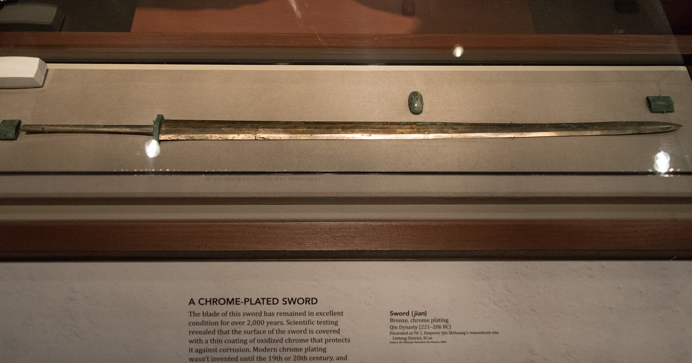 A long straight bronze sword from Pit 1 displayed in a museum case, its blade still bright after two thousand years