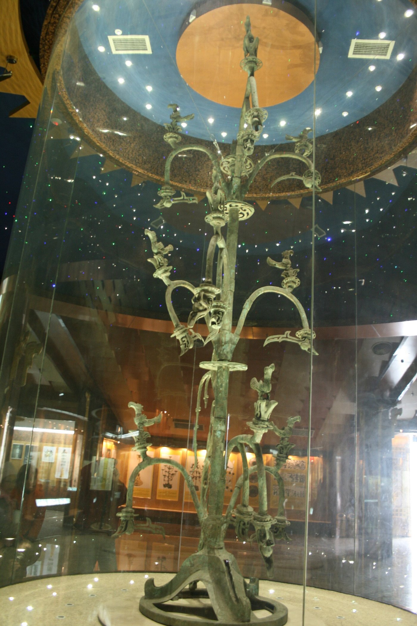 A tall bronze sacred tree from Sanxingdui with branches, birds and a coiling dragon