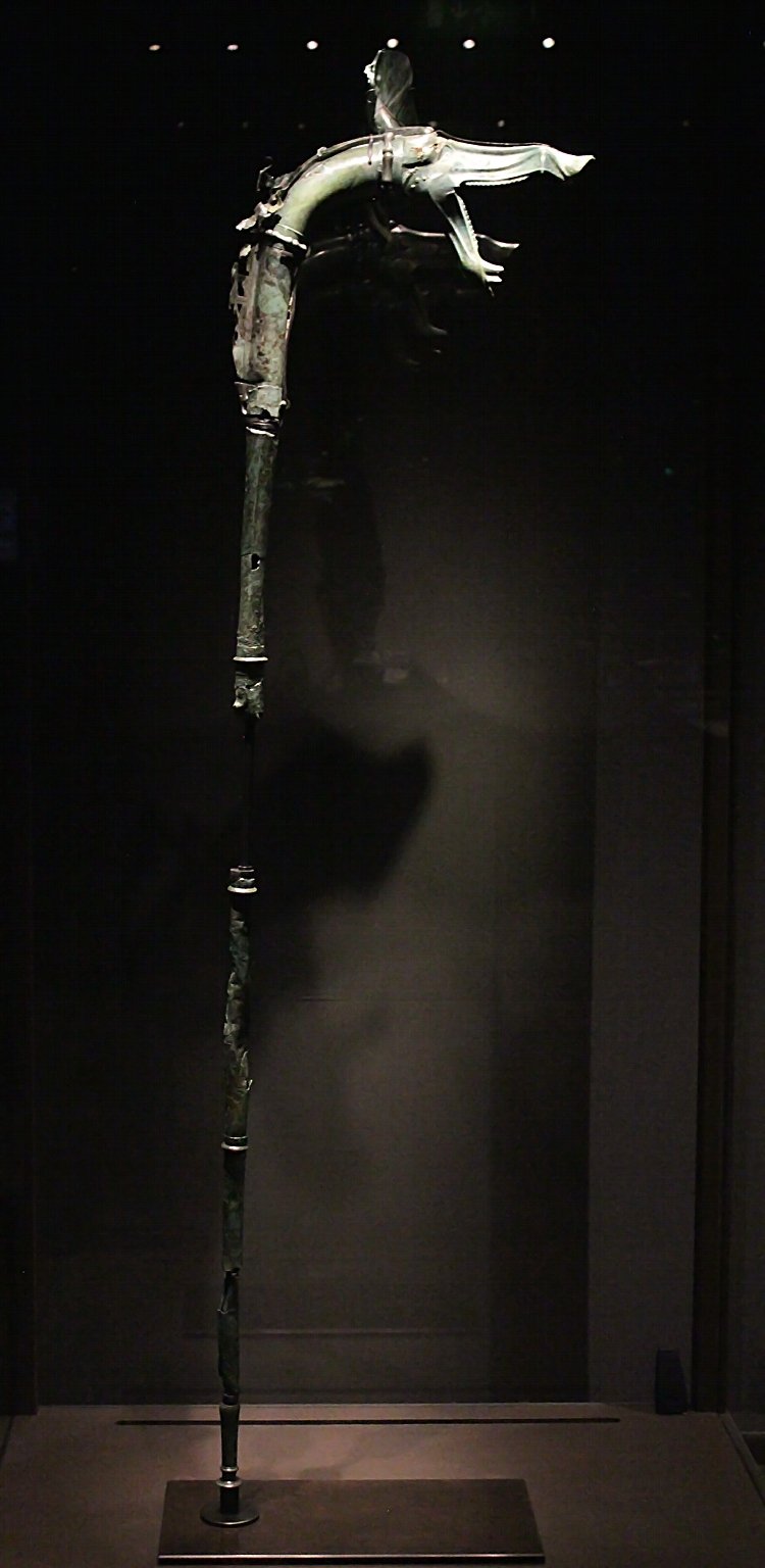 Reconstructed tall carnyces from Tintignac standing upright in a museum, boar and serpent heads at the top of long bronze tubes