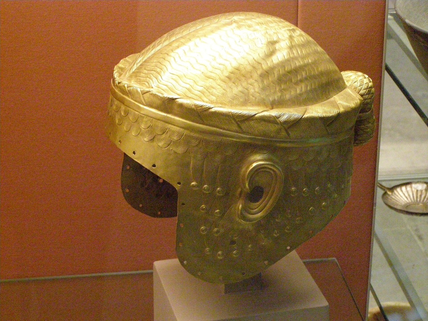 The gold helmet of Meskalamdug from Ur, hammered from a single sheet to resemble a wig with locks of hair and a knotted bun at the back