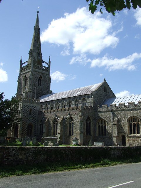 The Church of St Mary in Woolpit, Suffolk, a medieval church with a tall tower against a grey English sky