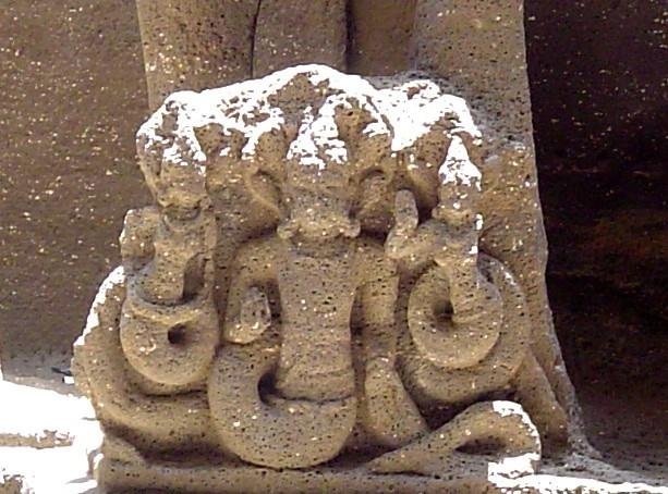 Detailed stone sculpture of a serpent deity at the Kailasa Temple, Ellora, carved in high relief