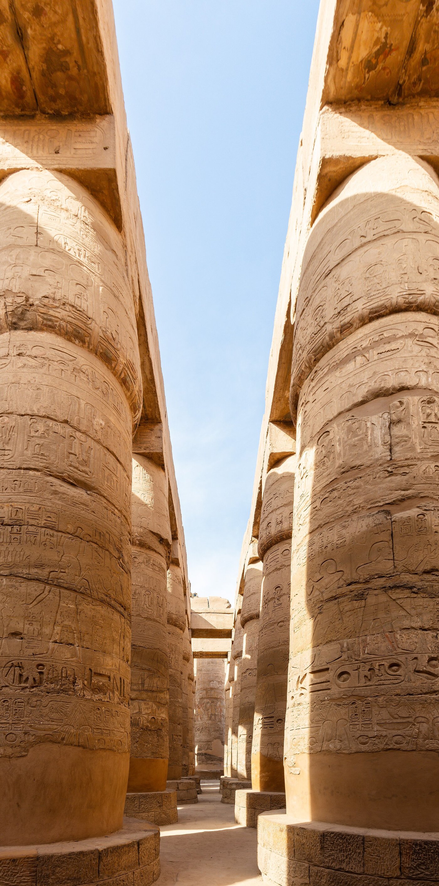 Rows of enormous carved sandstone columns in the Great Hypostyle Hall at Karnak