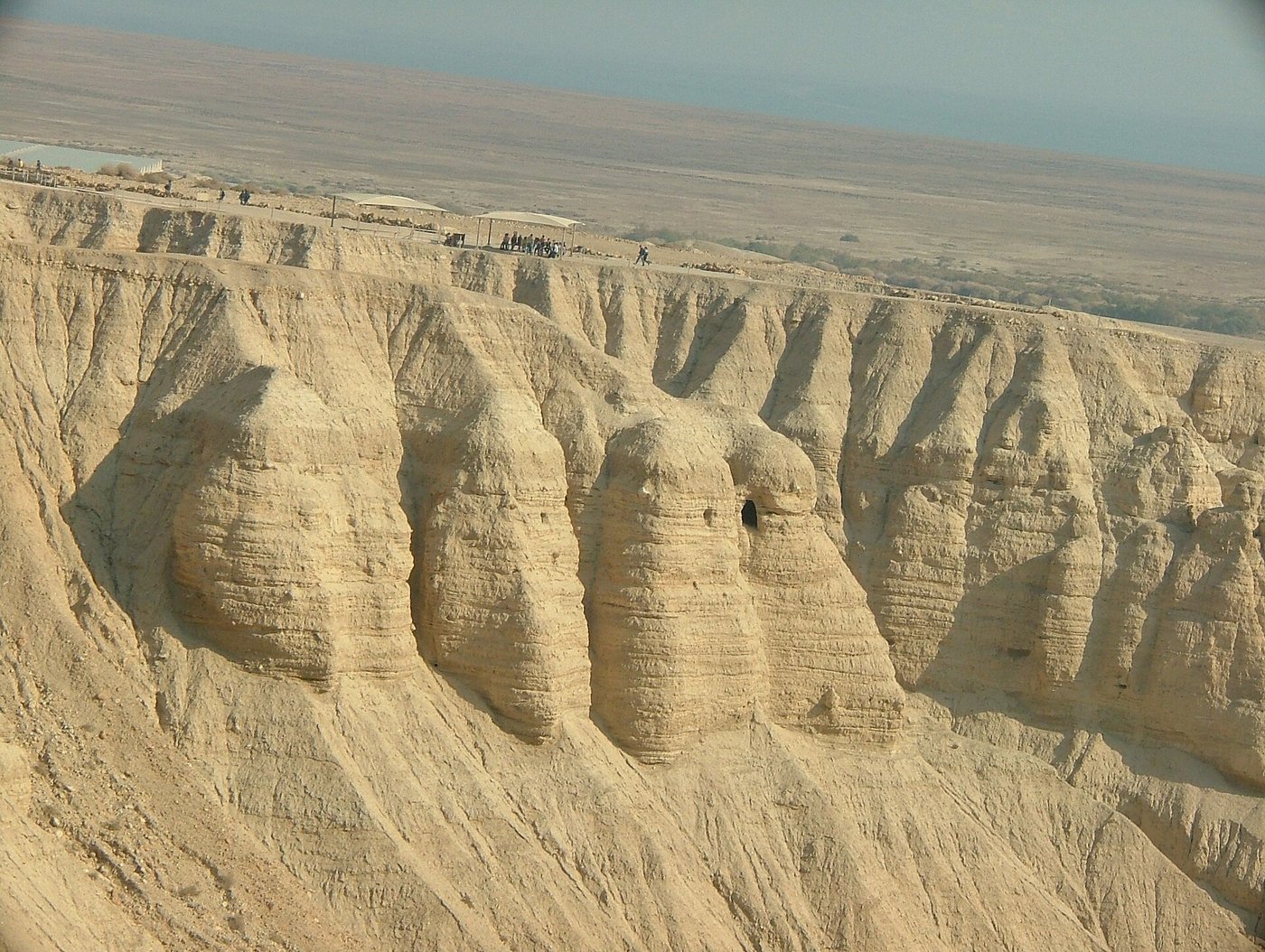 The dry limestone cliffs at Qumran riddled with caves above the Dead Sea