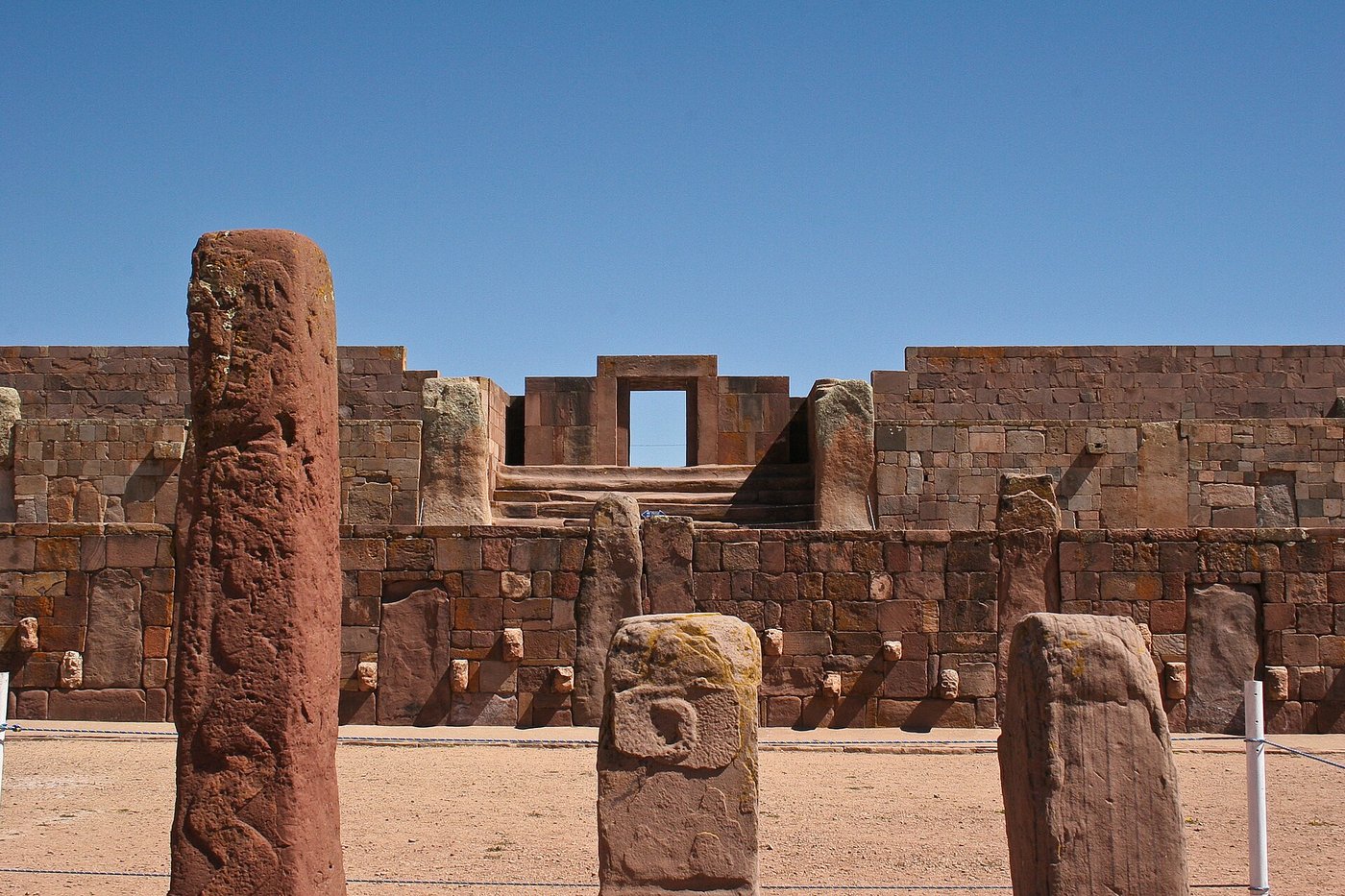 A monumental stone gateway and terraced wall of the Kalasasaya enclosure at Tiwanaku under a bright altiplano sky