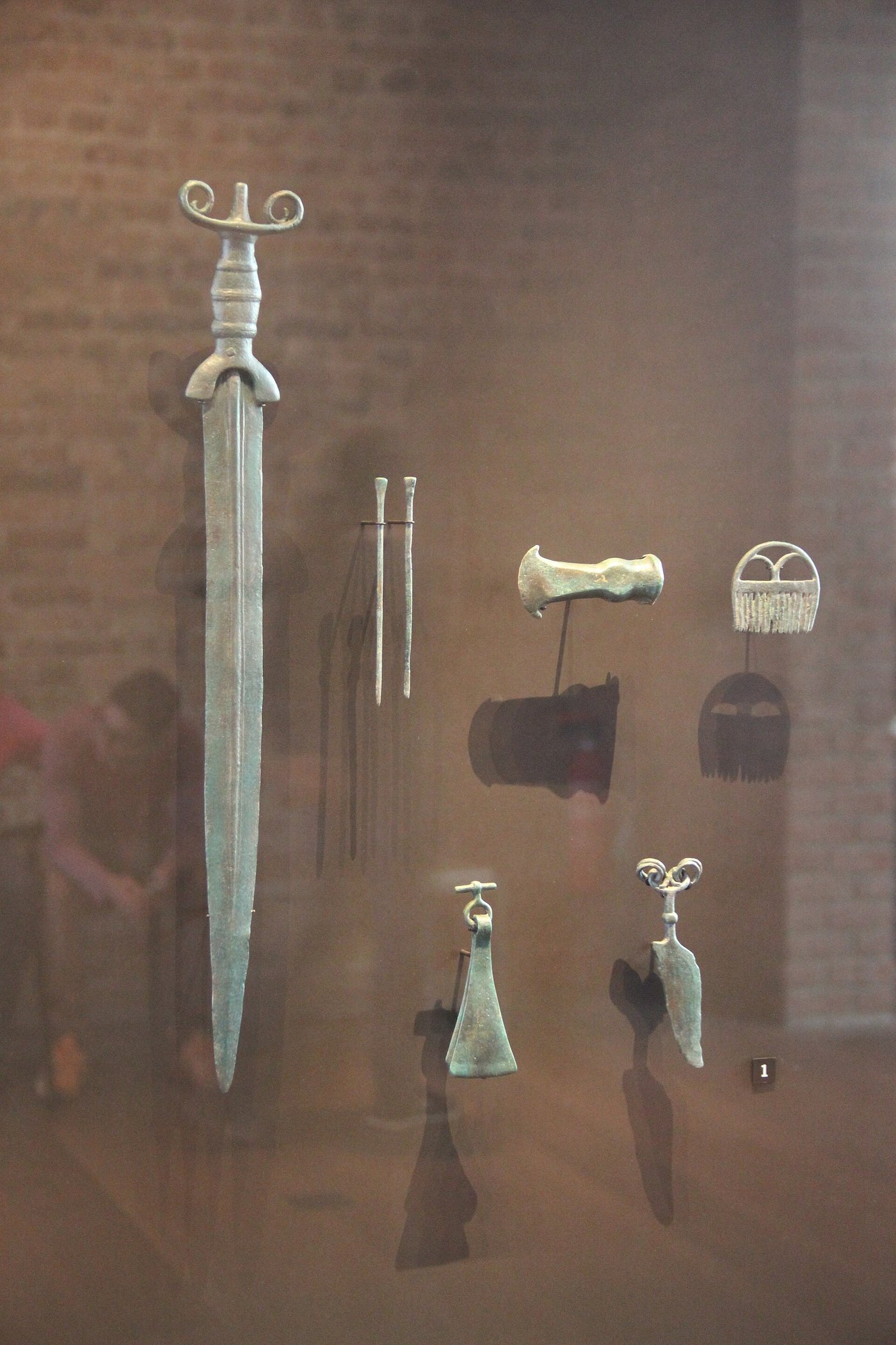 A museum case of Bronze Age European bronze swords and metal objects