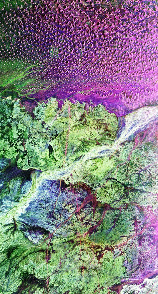 Space Shuttle imaging radar view of southern Oman, with ancient caravan tracks appearing as faint lines converging near Ubar