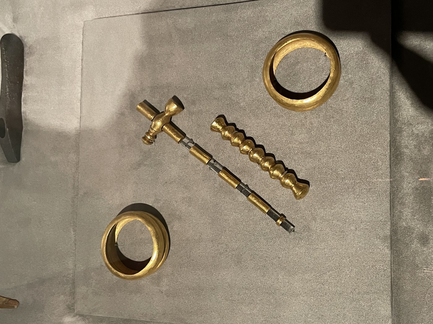 Gold bracelets and a gold-sheathed sceptre from the Varna necropolis on a dark background