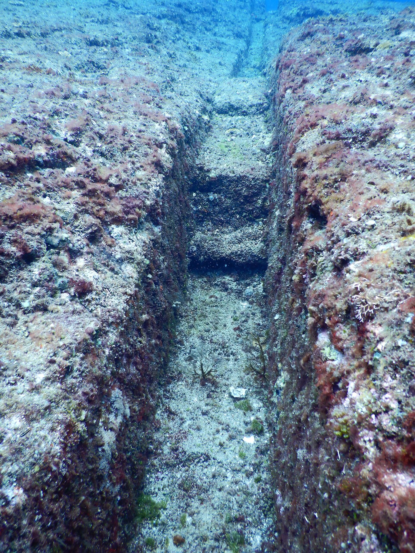 A long straight channel cut into the rock of the Yonaguni Monument, resembling a trench or drain