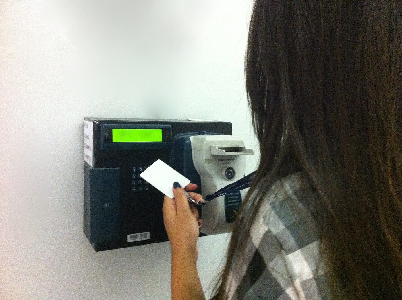 A worker swiping a card on a time clock